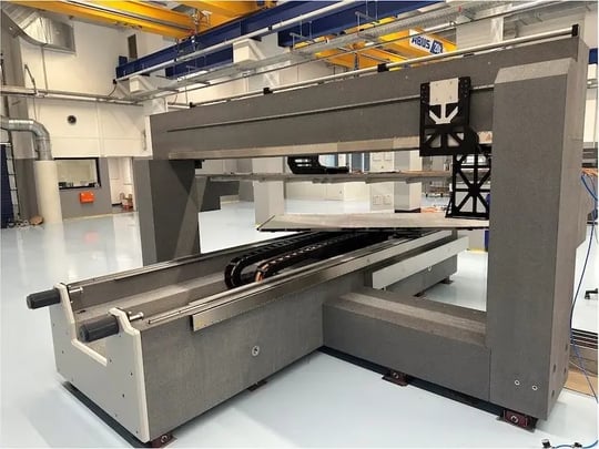 System mit U-förmiger Kabelführung und linearen Achsen auf Granitstruktur – Aufbau in moderner Fertigungshalle