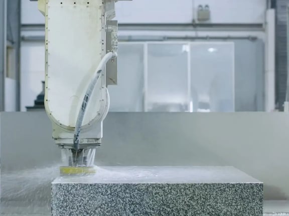 Vertical milling unit above brightly lit granite block